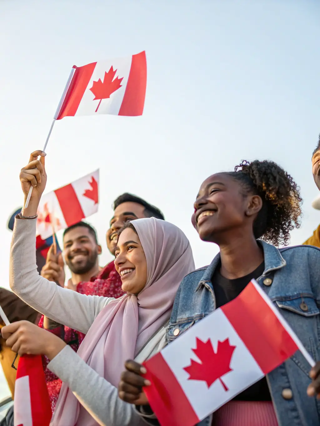 A Canadian citizenship ceremony, with new citizens proudly holding their certificates and Canadian flags.